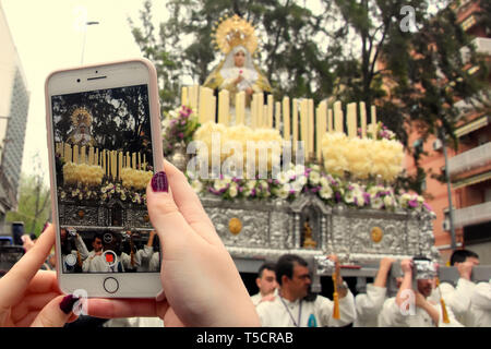 Aprile 21, 2019 - LÂ'Hospitalet, Catalogna, Spagna - una donna visto scattare foto della Vergine di rimedi sul suo smartphone durante la sfilata.Easter Parade 2019 Hospitalet. Una sfilata tipica della Spagna dove cristiano parrocchiani andare attraverso le sue strade con le statue della Vergine Maria e Gesù Cristo e si tratta di una tradizione cristiana sulle date di Pasqua. Credito: Ramon Costa/SOPA Immagini/ZUMA filo/Alamy Live News Foto Stock