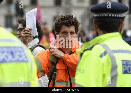 London, Greater London, Regno Unito. 23 apr, 2019. Estinzione attivisti di ribellione è visto in possesso di una lettera per la sua MP durante la ribellione di estinzione marzo a Londra.estinzione della ribellione manifestanti marzo da Marble Arch a Piazza del Parlamento, tentativo di recapitare lettere ai loro parlamentari. Estinzione della ribellione attivisti sono stati autorizzati ad essere in piazza del Parlamento ma non per entrare in Parlamento. Dopo diversi tentativi di consegnare le lettere, gli attivisti hanno raggiunto un accordo con MPs attraverso la polizia. Dieci attivisti sono stati autorizzati a consegnare le lettere in compagnia della baronessa Jenny Jones (G Foto Stock