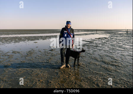 Cuxhaven, Germania. Xx Apr, 2019. Karsten Bronk è in piedi nel velme con il suo cane Bronko. Credito: Mohssen Assanimoghaddam/dpa/Alamy Live News Foto Stock