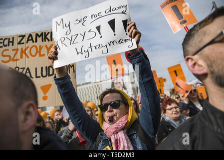 Varsavia, Mazowieckie, Polonia. 24 apr, 2019. Un manifestante visto tenendo un cartello dicendo, non daremo fino, saremo in grado di sopportare la crisi!, durante lo sciopero.24 aprile è stato il diciassettesimo giorno del polacco sciopero dei docenti. Migliaia di insegnanti e i loro sostenitori hanno marciato attraverso Varsavia, primo, al di fuori del Parlamento e dopo che il Ministero dell'Educazione Nazionale (uomini).Le richieste dei manifestanti sono ancora lo stesso - un aumento di stipendio fino a 1.000 PLN. Credito: Attila Husejnow SOPA/images/ZUMA filo/Alamy Live News Foto Stock