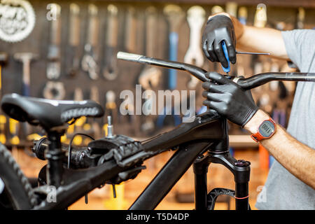 L'uomo la rimozione di volante dalla bicicletta al workshop Foto Stock