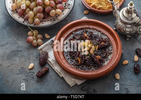 Slow manzo cotto tajine con date, uvetta e mandorle - cucina marocchina, spazio di copia Foto Stock
