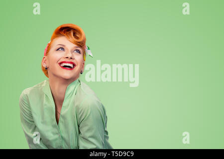 Primo piano della testa rossa giovane Excited donna graziosa ragazza pinup pulsante verde shirt sorridente ridendo guardando in alto isolato su sfondo giallo retro vintage 50's Foto Stock