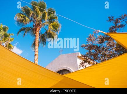 La cima della chiesa attraverso le decorazioni gialle della strada Foto Stock