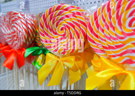 Rainbow lollipop swirl sul bastone di legno nel negozio di caramelle,fuoco selettivo.caramella dolce.candy bar.lecca-lecca vicino fino in vendita nel mercato di strada. Foto Stock