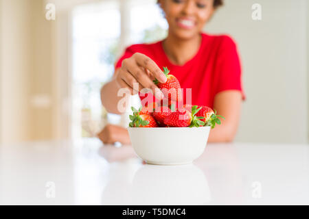 Close up della giovane donna di mangiare fragole fresche Foto Stock