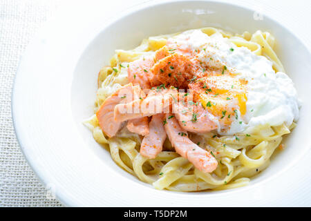 Fettucine con salmone, uova e formaggio parmigiano, servita su piastra bianca. Foto Stock