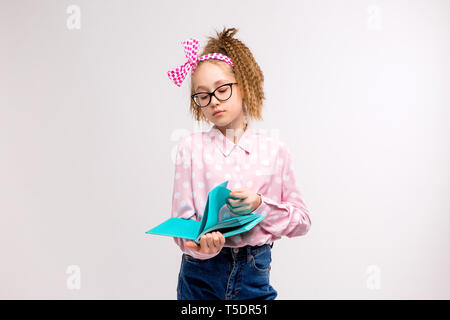 Ragazza giovane con occhiali, ragazza giovane con libro su sfondo bianco,sorridente ragazza tenere libri. Scuola ragazza con un sacco di libri da leggere per i compiti a casa,child wit Foto Stock