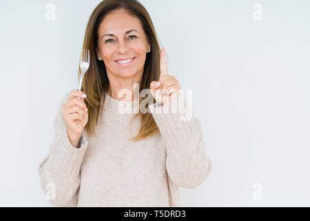 Medio Evo Woman holding argento metallico a forcella su sfondo isolato sorpreso con un'idea o domanda puntare il dito con la faccia felice, numero uno Foto Stock