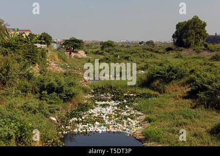 Immondizia di plastica e bottiglie di plastica lavati fino in un flusso, inquinamento, Phnom Penh Cambogia Foto Stock