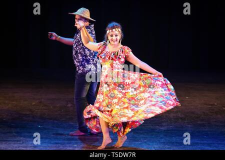 Giovane eseguire indiana tradizionale danza folk di Goa sul palco indossando costumi colorati Foto Stock