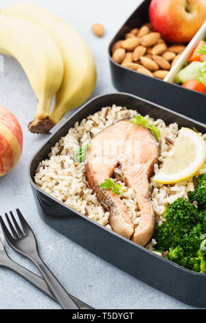 Sano e nutriente il pranzo o uno spuntino di scatole con il cibo - pesci, frutta fresca e verdura. Foto Stock