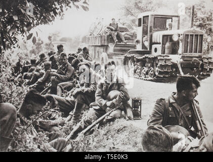 La fanteria tedesca a riposo su una strada dall'Ucraina (1941). Esso soddisfa in parte anteriore di essa solo un paese senza pietà danneggiato dai russi. Foto Stock