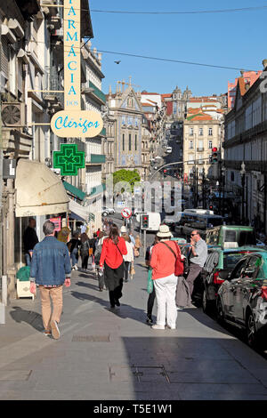 Vista posteriore delle persone che camminano sulla Rua dos Clerigos passato farmacia verso Capela das Almas nel quartiere Bolhao di Porto Portogallo Europa KATHY DEWITT Foto Stock