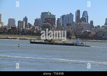 Rimorchiatore a traino sul New York Bay, con vista degli edifici nella parte inferiore di Manhattan, New York, Stati Uniti d'America Foto Stock