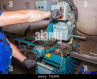 Lavoratori mani lavorando su una sega per metalli. Foto Stock