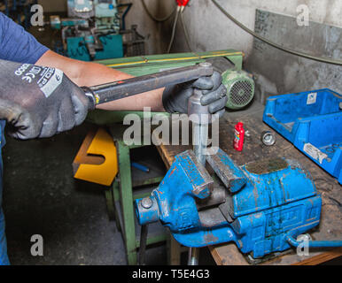 Mani lavorando su una morsa in un workshop. Foto Stock