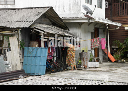 Donna panni appesi ad asciugare in area comunale di Bidayuh longhouse tribali, Kampung Annah Rais, Sarawak, Borneo, Malaysia Foto Stock