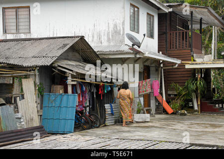 Donna panni appesi ad asciugare in area comunale di Bidayuh longhouse tribali, Kampung Annah Rais, Sarawak, Borneo, Malaysia Foto Stock