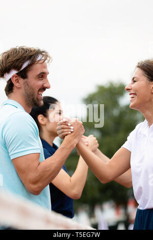 Un gruppo di giocatori di tennis dando una stretta di mano dopo una partita Foto Stock