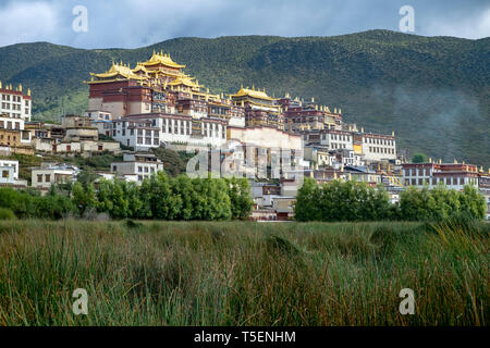 Songzanlin tibetano monastero buddista si riflette nel lago sacro, Shangri-La, nella provincia dello Yunnan in Cina Foto Stock