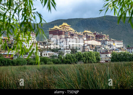 Songzanlin tibetano monastero buddista si riflette nel lago sacro, Shangri-La, nella provincia dello Yunnan in Cina Foto Stock