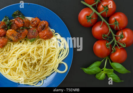 Pasta con i pomodori sulla piastra blu Foto Stock