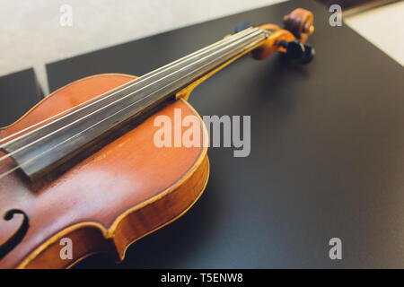 Il violino sul tavolo scuro, vicino - di violino sul pavimento di legno, vista dall'alto del violino musical su pavimento di legno scuro, vintage e classic musical Foto Stock