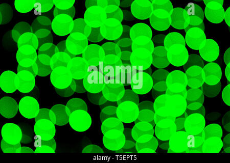 Abstract non focalizzato bokeh di fondo verde su sfondo nero. sfocati e sfocato numerose rotonde luce. Foto Stock