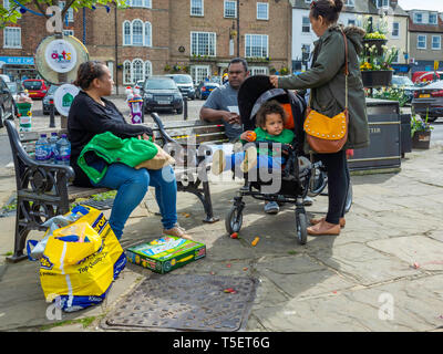 Un etnica Sud famiglia asiatica godendo una pausa dallo shopping e poggiante sulla Piazza del Mercato di Thirsk North Yorkshire Foto Stock