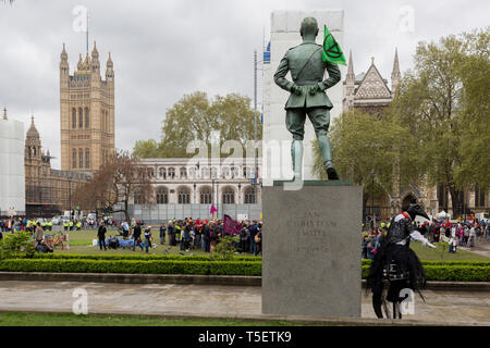 Al decimo giorno consecutivo di proteste intorno a Londra dal cambiamento climatico campagna ribellione di estinzione, un manifestante su palafitte si prepara a puntone di fronte europeo Square, il 24 aprile 2019, in Westminster, Londra Inghilterra. Foto Stock