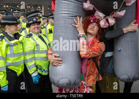 Al decimo giorno consecutivo di proteste intorno a Londra dal cambiamento climatico campagna ribellione di estinzione, un grande elefante gonfiabile permette di umorismo tra dimostranti e polizia, il 24 aprile 2019, a Marble Arch, Londra Inghilterra. Foto Stock