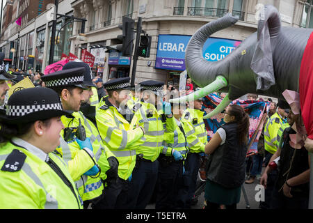 Al decimo giorno consecutivo di proteste intorno a Londra dal cambiamento climatico campagna ribellione di estinzione, un grande elefante gonfiabile permette di umorismo tra dimostranti e polizia, il 24 aprile 2019, a Marble Arch, Londra Inghilterra. Foto Stock