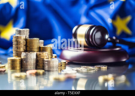 Torri con le monete in euro bandiera della Unione Europea e giustizia un martello in background. Foto Stock