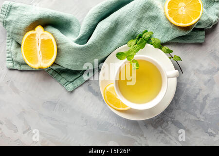 Una foto aerea di una tazza di tè verde con limoni e foglie di menta, con un posto per il testo Foto Stock