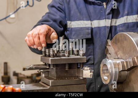 Colletto blu operatore macchina lavora con un tornio in una fabbrica. Foto Stock