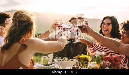 Un gruppo di giovani amici la tostatura bevande a parte. Giovani amici avente le bevande per celebrare una occasione speciale. Foto Stock