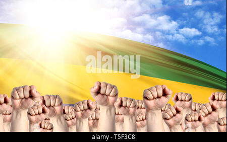 La giornata del lavoro concetto con i pugni di uomini contro lo sfondo della bandiera del Gabon Foto Stock
