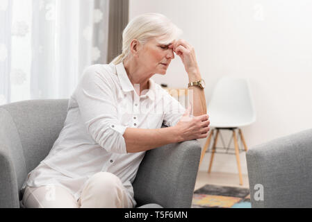 Donna anziana ha un mal di testa. Senior il concetto di assistenza sanitaria Foto Stock