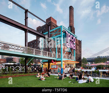 Ristorante Tacocina contro lo sfondo del Domino ex fabbrica di zucchero. Domino Park, Brooklyn, Stati Uniti. Architetto: James angolo opera sul campo Foto Stock