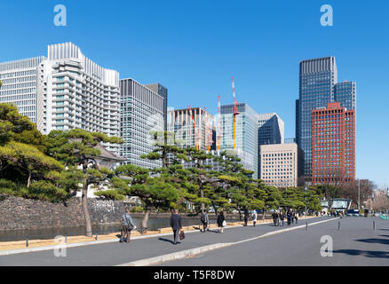 Tokyo, Marunouchi. Grattacieli del quartiere Marunouchi con il fossato e le pareti del Palazzo Imperiale in primo piano, Tokyo, Giappone Foto Stock