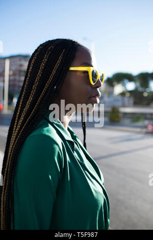 Nero donna indossando occhiali da sole giallo a Madrid Foto Stock