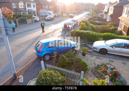 Scena di un traffico stradale collisione, dove un auto ha perso il controllo ed è venuto a riposo in un giardino. 2 occupanti sono stati visto correre lontano dalla scena. Foto Stock