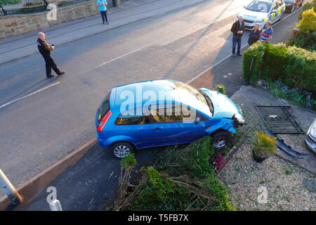Scena di un traffico stradale collisione, dove un auto ha perso il controllo ed è venuto a riposo in un giardino. 2 occupanti sono stati visto correre lontano dalla scena. Foto Stock