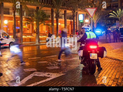 Luci blu su motociclisti della polizia in strada bagnata di notte pattugliando la sfilata di Pasqua del 2019 durante la settimana Santa ad Alicante, spagna Foto Stock