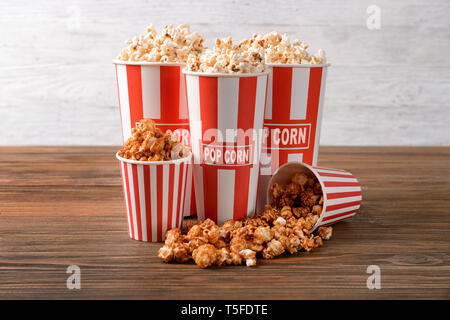 Tazze con gustosi popcorn sul tavolo di legno Foto Stock