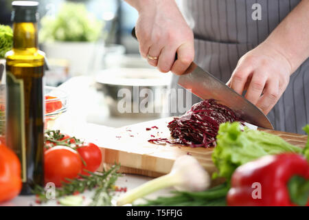 Chef professionale le mani per affettare il cavolo viola Foto Stock