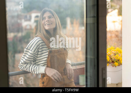 Ritratto di sorridente ragazza rilassante sul balcone Foto Stock