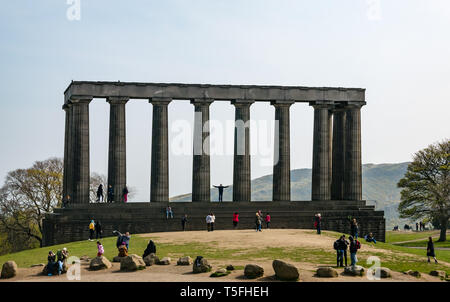 Turisti e arrampicata in piedi sul Monumento Nazionale di Scozia, Calton Hill, Edimburgo, Scozia, Regno Unito Foto Stock