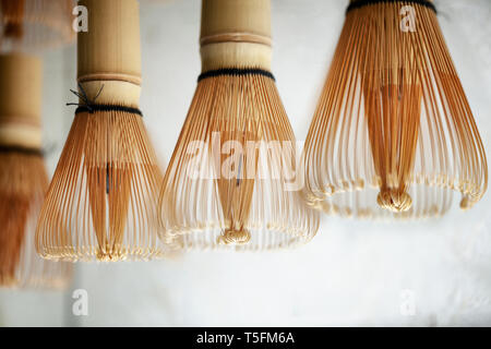 Il bambù Matcha tè frusta spazzola contro un muro bianco sullo sfondo Foto Stock